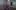 Holly Blakey sits in an empty dance rehearsal studio. She has slicked back red hair and wears a pink sweater with the word \'TRUE\' in large letters on the front. Behind her we can see a large mirrored wall reflecting the rest of the studio space