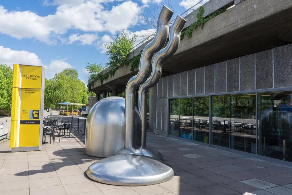 A photograph showing Riverside Terrace at Southbank Centre, with the metal sculpture Zemran in the foreground, next to Queen Elizabeth Hall