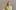 Kirsty Young wearing a pale green suit against a beige background.