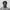 Black and white head shot of Sauti Choir member J Cocoa, posing against the wall of the Royal Festival Hall.