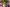 A large, diverse women\'s choir sings passionately outdoors, wearing vibrant, colorful patterned dresses and traditional garments.