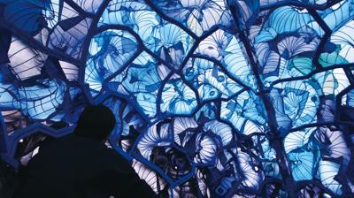 An enveloping blue installation, the silhouette of a person is in the foreground