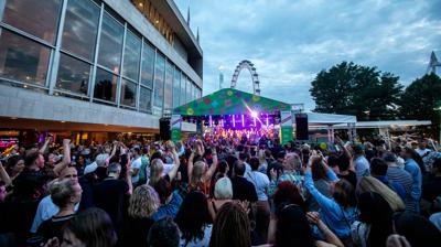 A crowd of people on the Riverside Terrace with the London Eye in the background