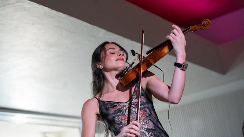 A violin player engrossed in their playing