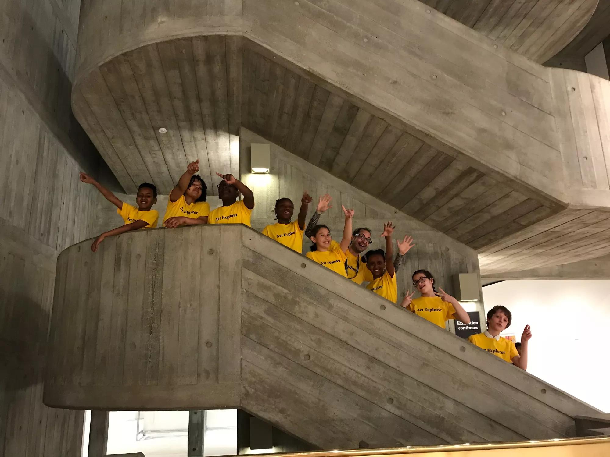 Children standing and waving on a concrete staircase
