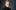 Michael Douglas with grey hair wearing a black leather jacket and a green turtleneck