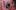 A little child with ginger hair is peeking through an installation in Replay.