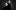 A black-and-white studio portrait of two men in black turtlenecks standing staggered against a grey gradient background.