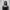 Barakat Omomayowa, a young black woman with long dark hair stands in front of a concrete wall