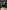 Octavia has shoulder length dark brown hair and is photographed at a table infront of some bookshelves. She wears a long sleeved black shirt and red lipstick. She leans against her palm and smiles towards the camera. 